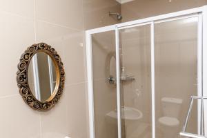 a bathroom with a shower and a mirror on the wall at Nkosazana Guest House in Durban