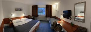 een hotelkamer met een bed en een televisie bij Cascade in Stuttgart