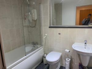 a bathroom with a toilet and a sink and a shower at City Centre 2 bedroom apartment, secure parking. in Glasgow
