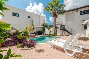 Villa con piscina y 2 sillas en Villa Fontana 1 & 2 en Palm-Eagle Beach