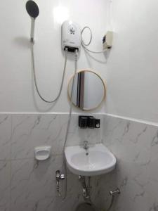 La salle de bains est pourvue d'un lavabo et d'un miroir. dans l'établissement Deja Homestay Siargao, à Del Carmen