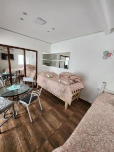 Habitación con 2 camas, mesa y sillas en Departamento ubicadisimo calle chile con estacionamiento incluido capital Mendoza 7 en Mendoza