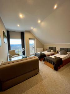 a large room with two beds and a couch at Willa Hańcza in Smolniki