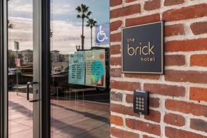a sign on the side of a brick building at The Brick Boutique Hotel in Oceanside