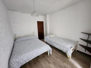 a bedroom with two beds and a door at Departamento ubicadisimo calle Chile con estacionamiento incluido capital Mendoza3 centro in Mendoza
