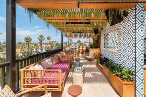 a patio with couches and tables on a balcony at The Brick Boutique Hotel in Oceanside