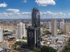 a tall building in the middle of a city at Estúdio Confortável no 12º Andar do Ed. Vertigo in Campo Grande