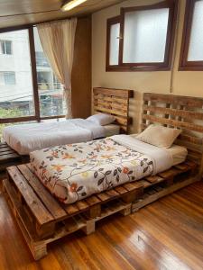 twee bedden op een houten platform in een kamer met ramen bij Blue house La Floresta in Quito