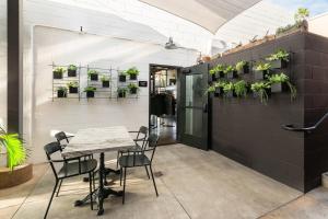 a table and chairs in a room with plants on the wall at The Brick Boutique Hotel in Oceanside