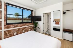 a bedroom with a brick wall and a window at The Brick Boutique Hotel in Oceanside
