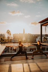 two women performing a yoga pose on a rooftop at The Brick Boutique Hotel in Oceanside