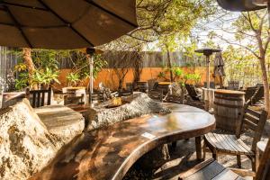 a large stone table with chairs and an umbrella at The Brick Boutique Hotel in Oceanside