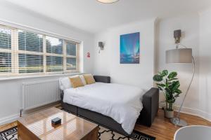 a small bedroom with a bed and a table at FLATZY - Quiet Sefton Park Luxury Apartment in Liverpool