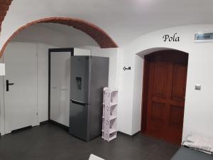 Habitación con nevera y puerta de madera. en Słoneczne Apartamenty, en Sokołowsko