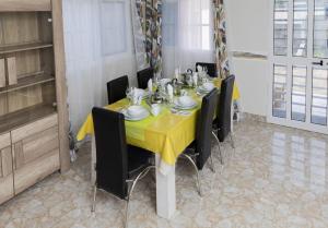 comedor con mesa amarilla y sillas en Maison Bethel Kpogan Afidenigba 