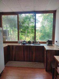 a kitchen with a sink and a large window at ROOM COLIBRÍ - La Casa de Eros in Ayampe