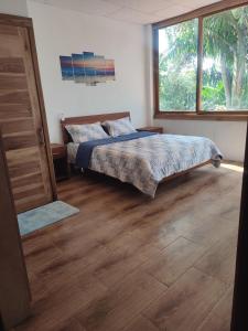 um quarto com uma cama e uma grande janela em ROOM COLIBRÍ - La Casa de Eros em Ayampe