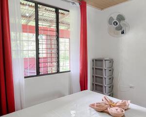 a bedroom with a bed and a window and a fan at Villa Rincón del Arenal in Fortuna