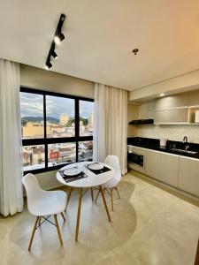a kitchen with a table and chairs and a large window at Apts 501 e 705 Diamond Flats in São Lourenço