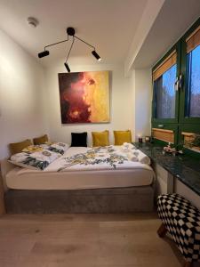 1 dormitorio con 1 cama con una pintura en la pared en Gold Pearl Zegrze, en Serock