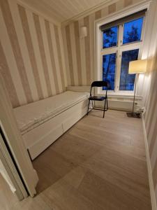Habitación pequeña con cama y silla. en Det Gamle Meieriet en Vidnes