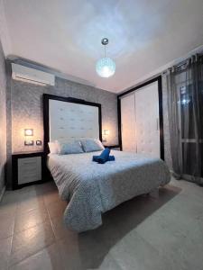 um quarto com uma cama grande e uma almofada azul em Oasis em Arcos de la Frontera