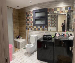 um homem tirando uma foto de uma casa de banho com um WC em شقه فندقيه VIP no Cairo