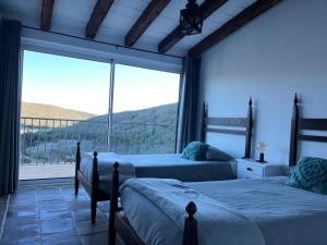 a bedroom with two beds and a large window at Nature&Soul - MAR in Vila do Bispo