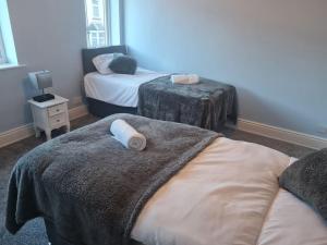 a bedroom with two beds with towels on them at Primrose Stays - 3 bedroom House in Stoke on Trent