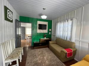 sala de estar con sofá y pared verde en Casa Suzena 300 metros Parque e Praias, en Penha
