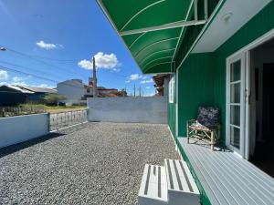 a bench sitting on the side of a green building at CASA SUZENA - Penha SC a 300 metros do Beto Carrero e Praias in Penha