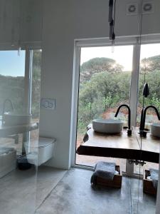 a bathroom with two sinks and a large window at Nature&Soul - MAR in Vila do Bispo