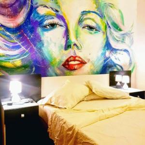 una pintura de una mujer en una pared junto a una cama en Montevideo Port Hostel en Montevideo