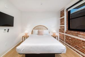 a bedroom with a bed and a brick wall at The Brick Boutique Hotel in Oceanside