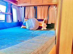 małe łóżko na tyłach autobusu w obiekcie Caravanas Con Encanto El Palmar 2 w mieście El Palmar