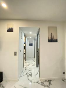 pasillo con suelo de mármol, paredes blancas y espejo en Modern appartment Palma, en Palma de Mallorca