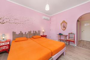 ein Schlafzimmer mit einem großen orangenen Bett in einem Zimmer in der Unterkunft Al-Gharb Tavira Eco GuestHouse in Tavira
