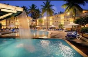- une piscine avec une fontaine en face de l'hôtel dans l'établissement Studio dans Résidence Hotelière aux 3ilets Pointe du bout Résidence la Marina Carayou, à Les Trois-Îlets
