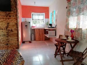 Una habitación con una mesa y una cocina con nevera. en Casa Chen-Huaye, en Isla Mujeres