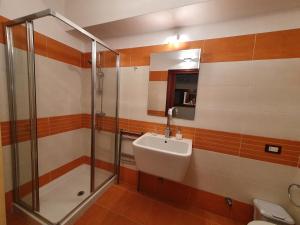 y baño con lavabo y ducha. en Casa La Ferula apt1 vicino al mare e Taormina, en SantʼAlessio Siculo