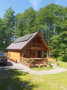 a large log cabin with a solar roof at Ranczo Rykowisko in Kołodzieje