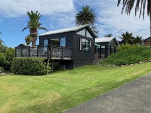 a black house with a palm tree in front of it at Art Lovers Retreat in Onetangi