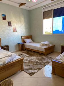 una camera con due letti e una finestra di Doudane Guest House Surf Morocco a Tamraght Ouzdar