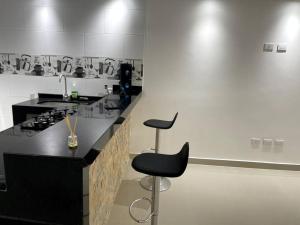 a kitchen with a black counter and a stool at Hermoso apartamento en turbaco in Turbaco