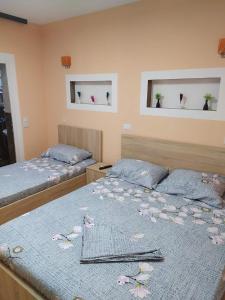 1 dormitorio con 2 camas y 2 ventanas en Grandino rooms&apart, en Ulcinj