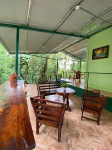 a room with wooden tables and chairs and windows at Grettel´s House Apartments, La Fortuna de San Carlos in Fortuna