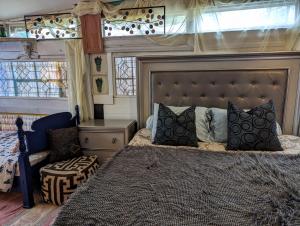 een slaapkamer met een bed, een bank en ramen bij Villa Anita in Death Valley in Tecopa