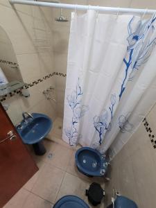 a bathroom with a toilet and a sink and a shower curtain at Departamento a estrenar en pleno centro de Salta 1 dormitorio in Salta