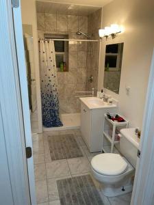 uma casa de banho com um WC, um chuveiro e um lavatório. em 3 Bedrooms cozy comfortable vacation home downtown Gatineau Ottawa near Parliamant and Park em Gatineau