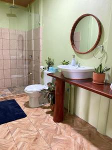 y baño con lavabo, aseo y espejo. en Grettel´s House Apartments, La Fortuna de San Carlos, en Fortuna